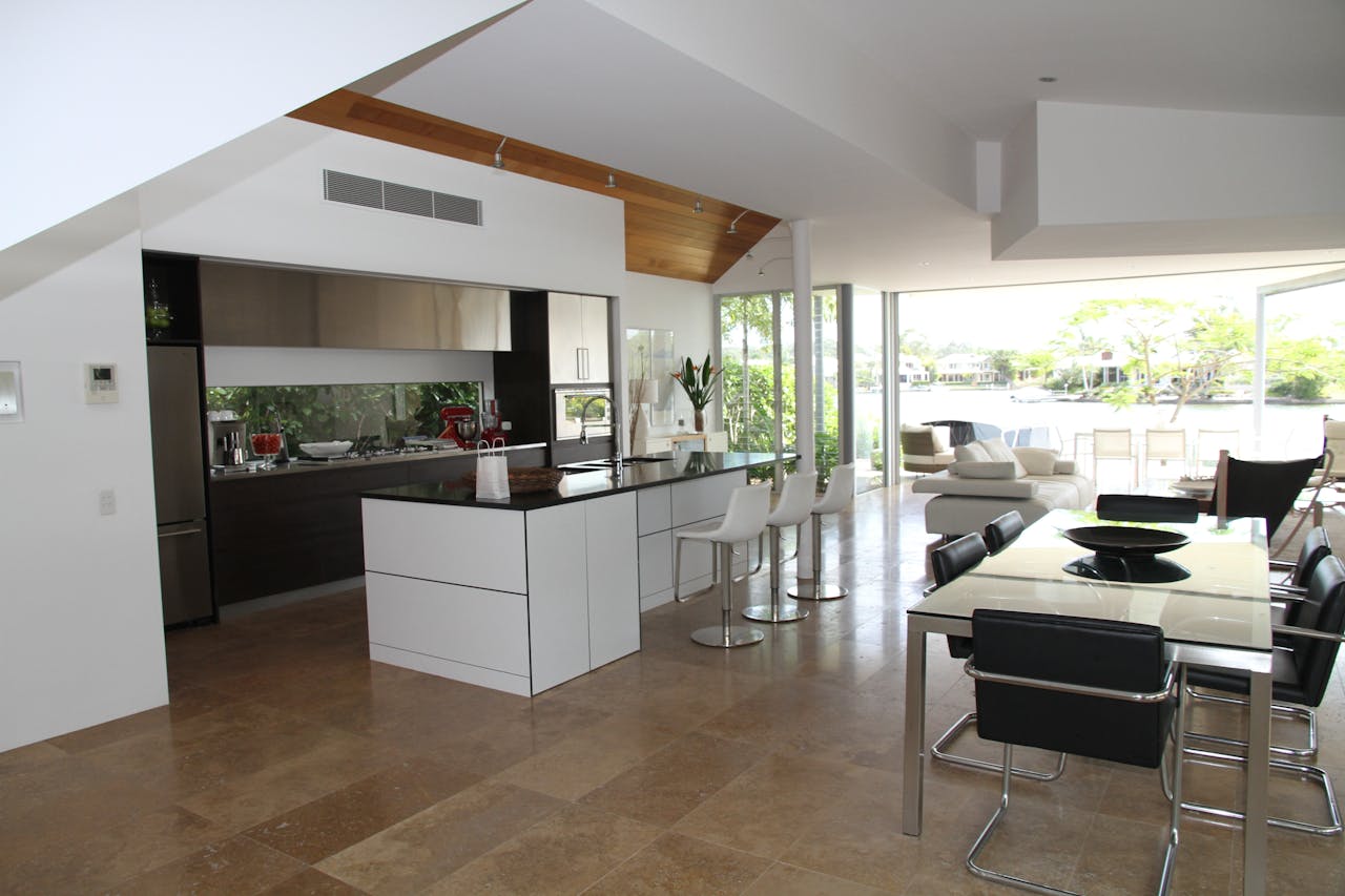 services-01 Spacious modern kitchen and living room with open design overlooking a scenic outdoor view.